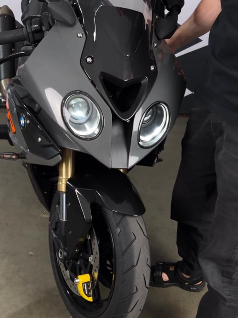 A hand rocking the motorcycle by the handlebar with the LoudLock on